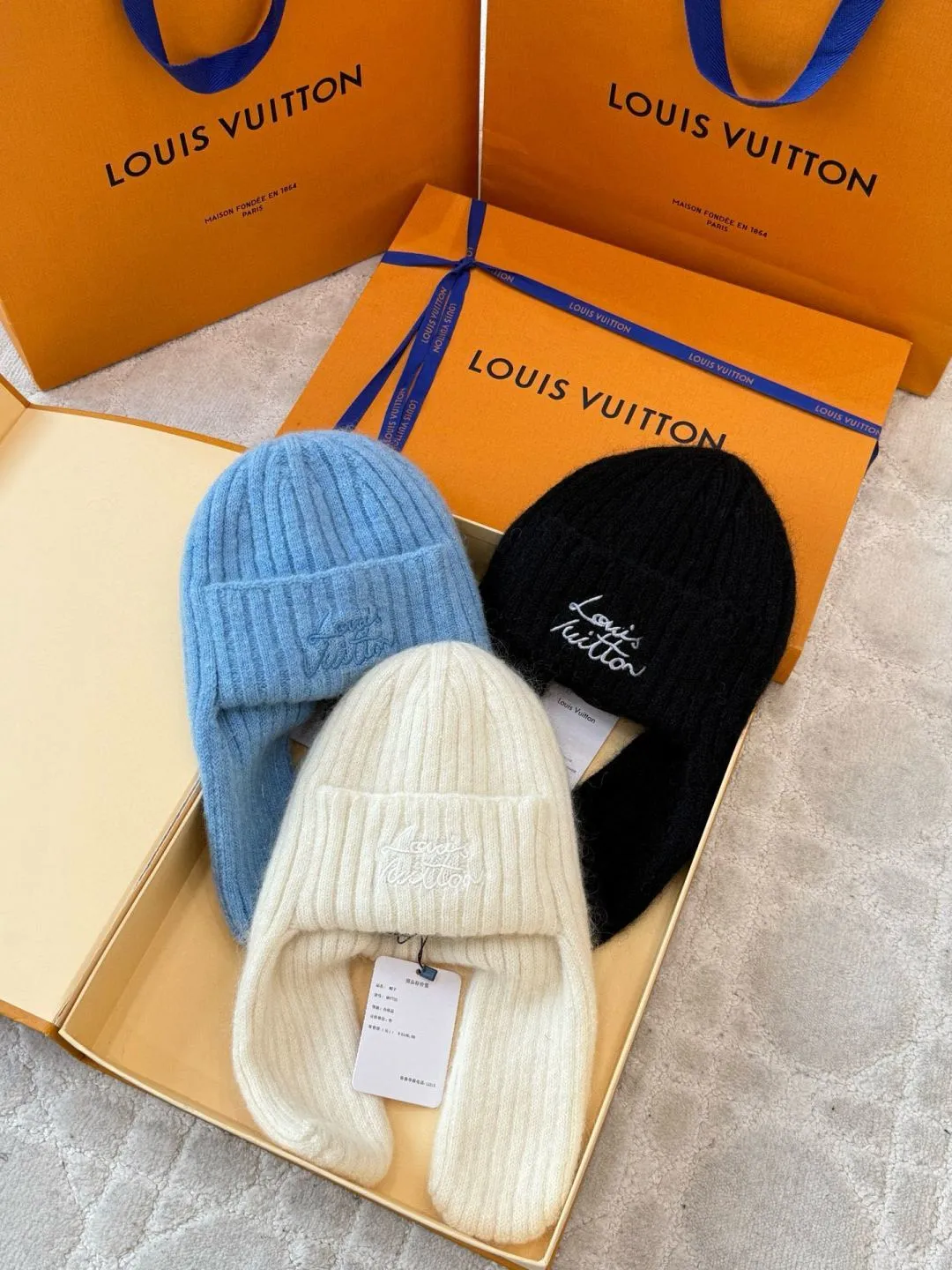 LOUIS VUITTON Autumn and Winter Ski Series Lei Feng Hat ●Original version: 5100 purchase and development ●Item number: 1681971-B05 ●Fabric: wool blended fabric ●Technology: knitted ●Color: white/black/Iceland blue/ ●Version: suitable fit ●Description: Woven by 32-needle fine knitting technology, the suede surface is fluffy and smooth, and its warmth retention is better than ordinary wool hats. The main body of the hat has a vertical grooved stripe texture, which is elastically fit through the fixed-needle shrinking technique. It is suitable for most headbands. The front logo of the hat is made of three-dimensional satin embroidery. The embroidery thread is made of high-gloss yarn of the same color. The stitch density reaches 80 stitches/square centimeter. The pattern is full and not easy to pilling. The ear protection part is woven in one piece, without splicing gaps, making it more comfortable to wear. The finished product is shaped by low-temperature steam to ensure that the hat shape is stiff and not easily deformed. The post-finishing process includes anti-pilling treatment, taking into account both texture and durability. The overall wiring is straight and delicate, the fabric is comfortable and soft, and the color is consistent without color difference. It can be matched with the same style to create a fashionable look and control various occasions. Customized accessories, complete with three standards, same style for men and women!
